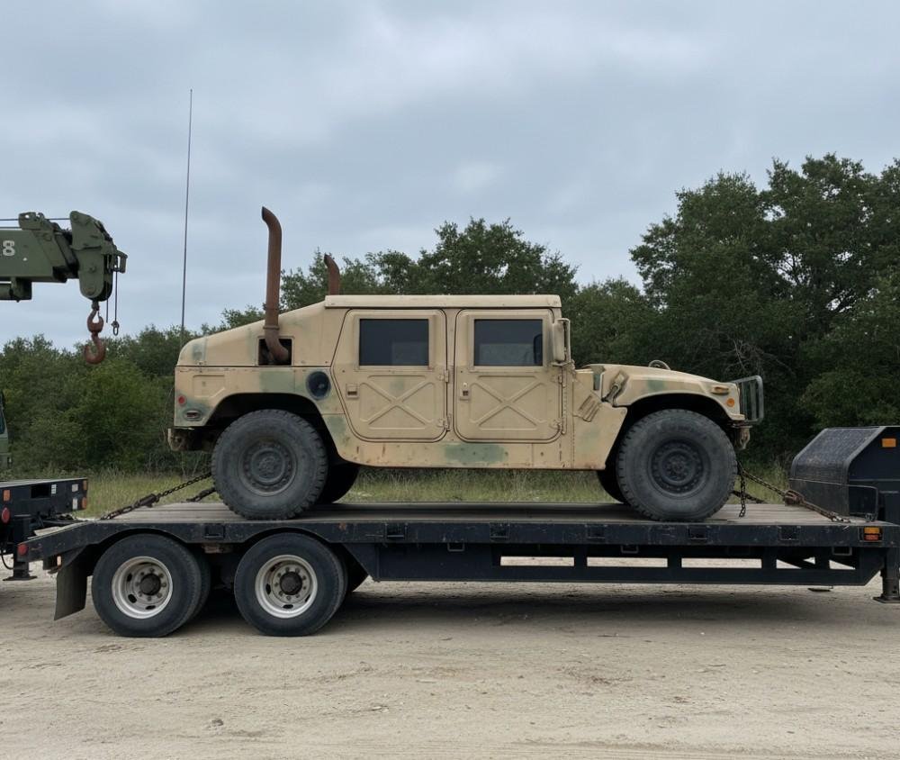 Military vehicle transport flatbed trailer carrying desert camouflage Humvee